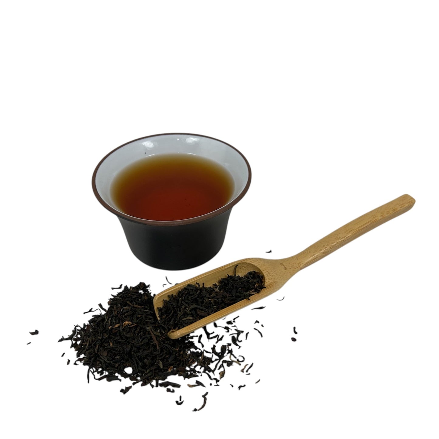 Thé noir assam breakfast dans une tasse de style asiatique avec feuilles de thé en vrac
