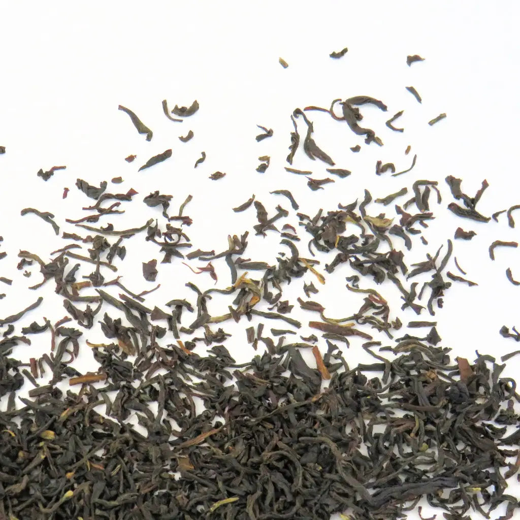 Feuilles de thé noir Assam Banaspaty séchées étalées sur la table en gros plan.
