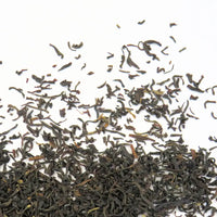 Feuilles de thé noir Assam Banaspaty séchées étalées sur la table en gros plan.